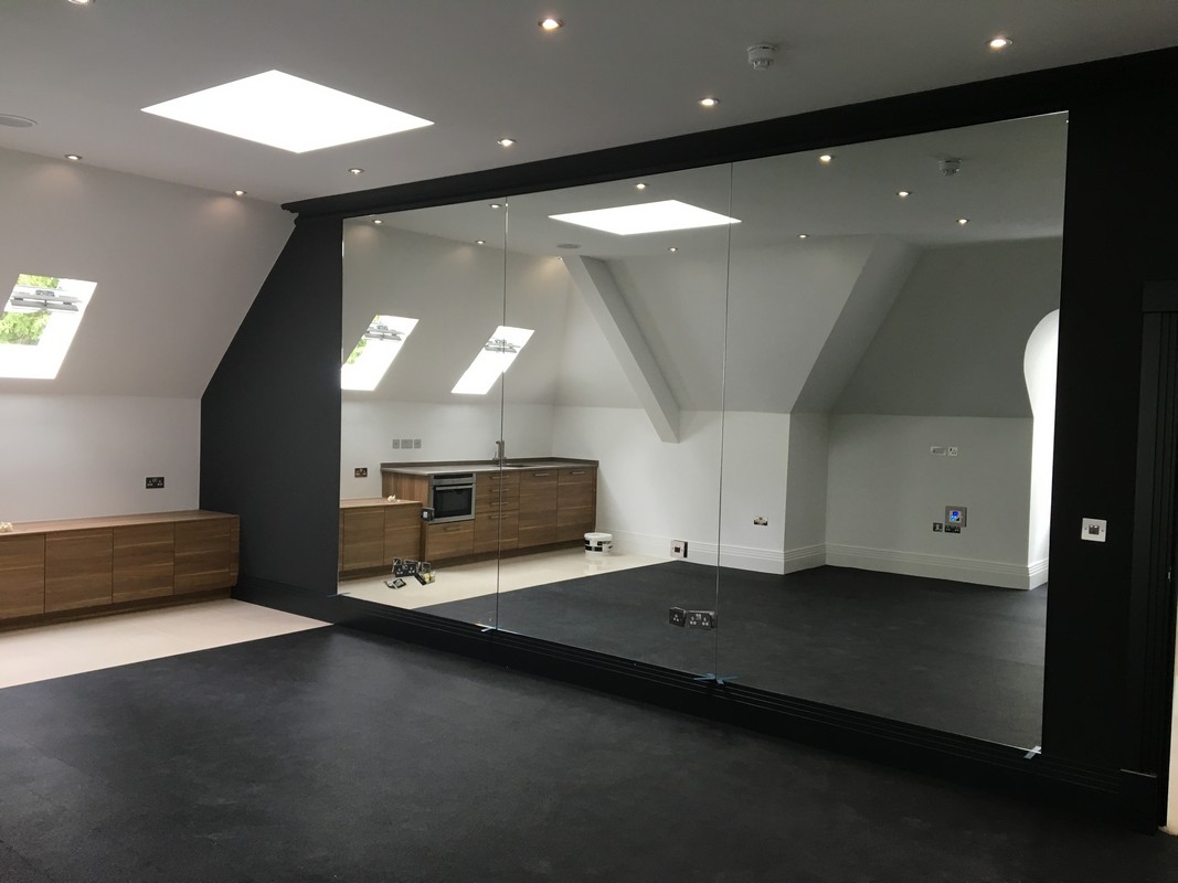Frameless glass wall dividing loft conversion in Sutton